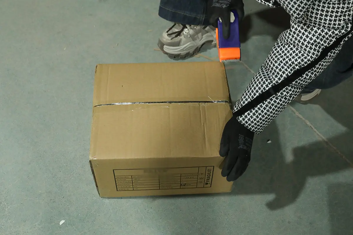 Master export carton being sealed and secured for shipment