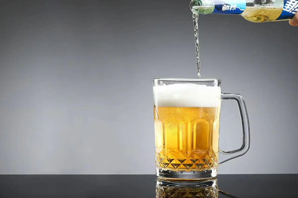 Classic beer mug stein glass with handle filled with pale beer