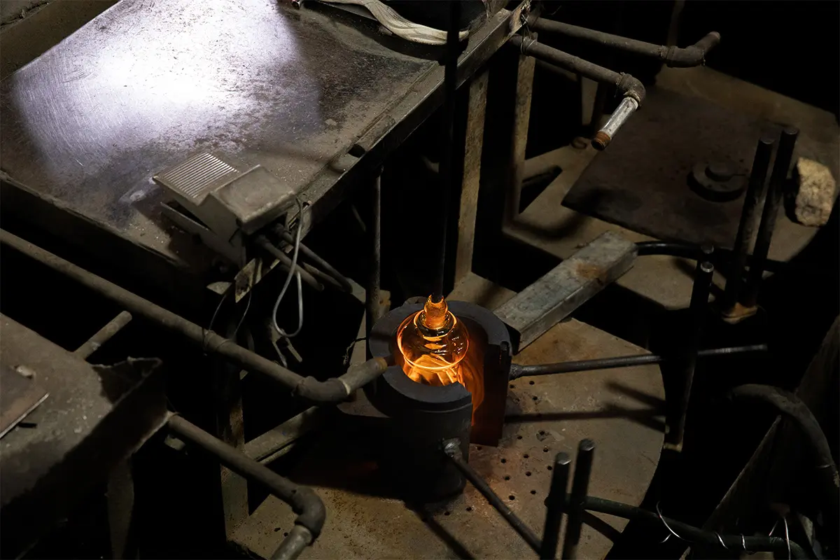 Workers hand blowing glass in the production workshop