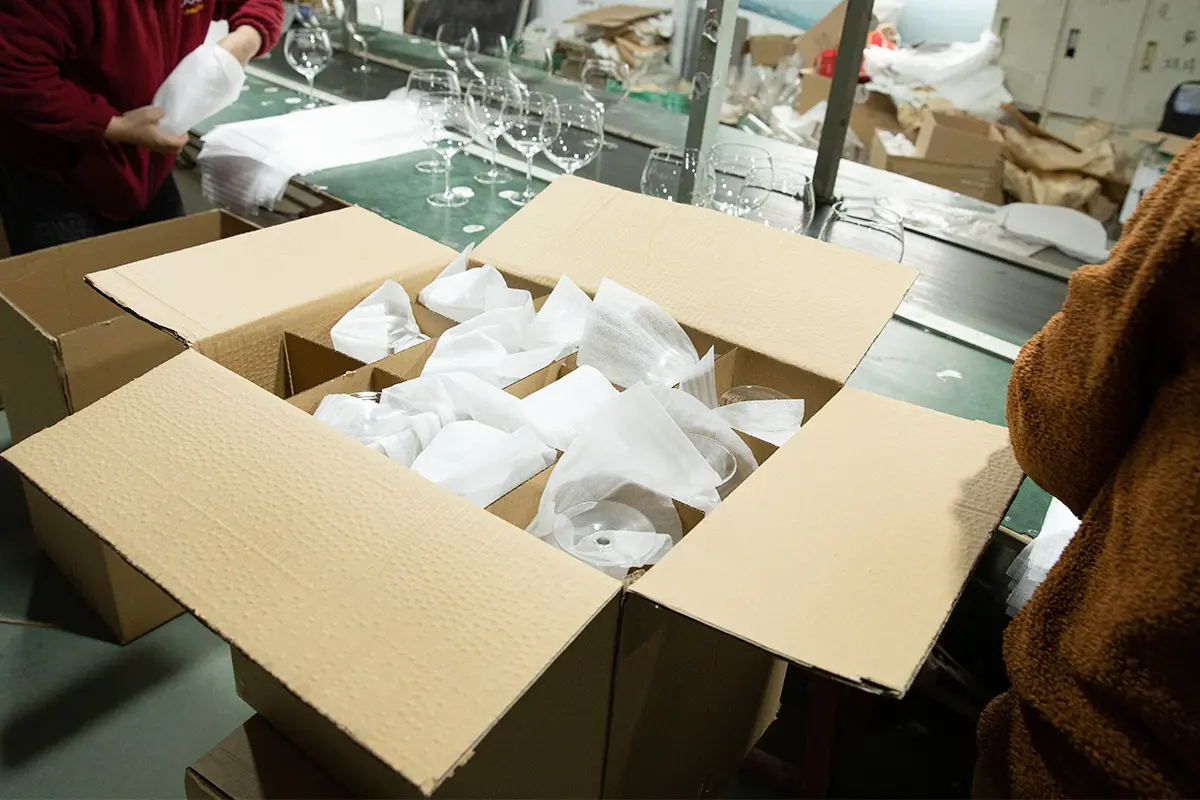 Worker packing glass cups with protective partition packaging