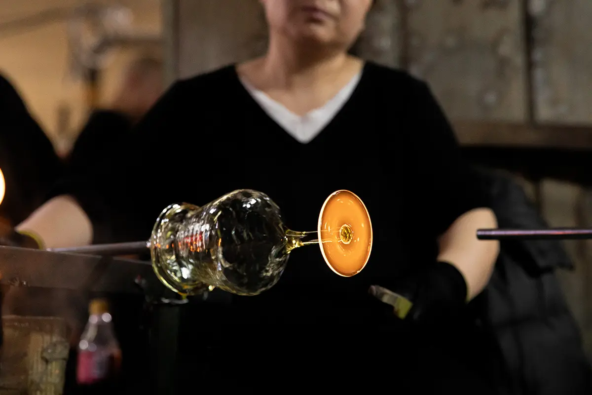 Skilled worker shaping the base of a stemmed glass by hand